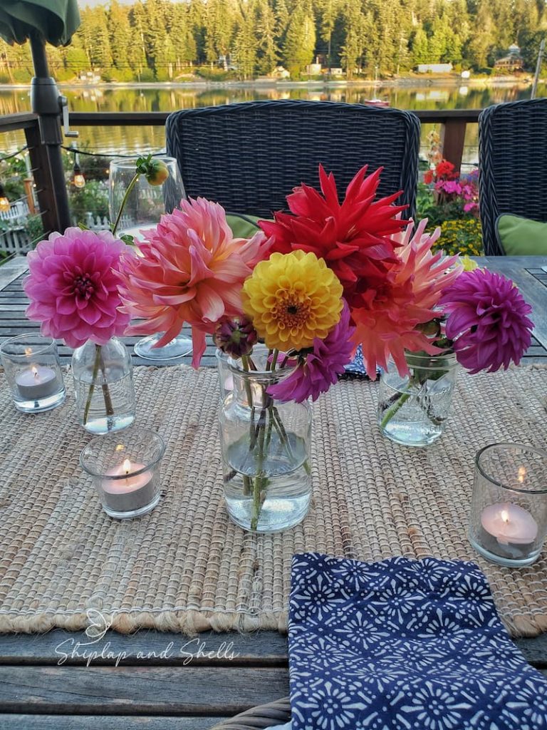 glass jars filled with bright colored dahlias from the garden