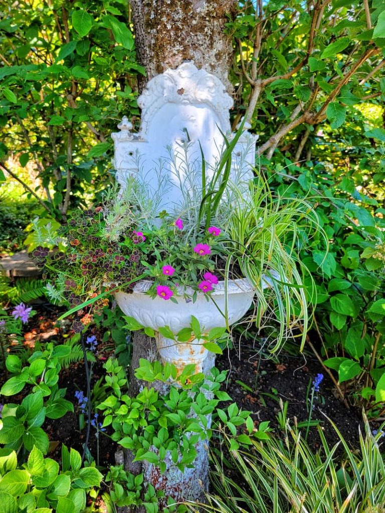 vintage garden decor: hanging vintage fountain with flowers