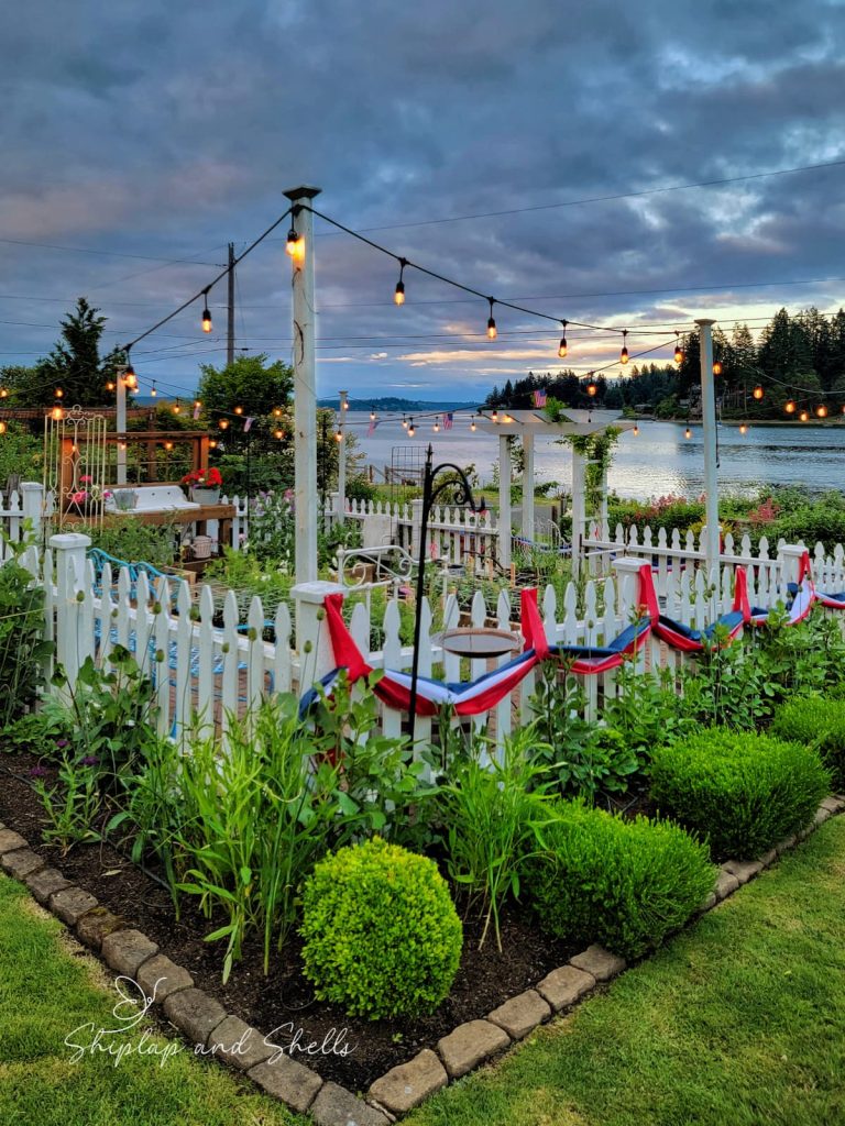 red, white, and blue banners on white picket fence