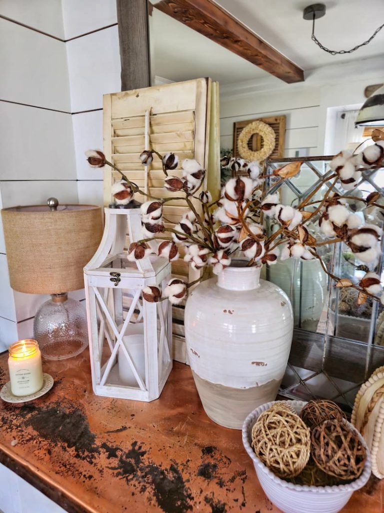 neutral fall decor ideas: cotton stems in ceramic vase and lantern