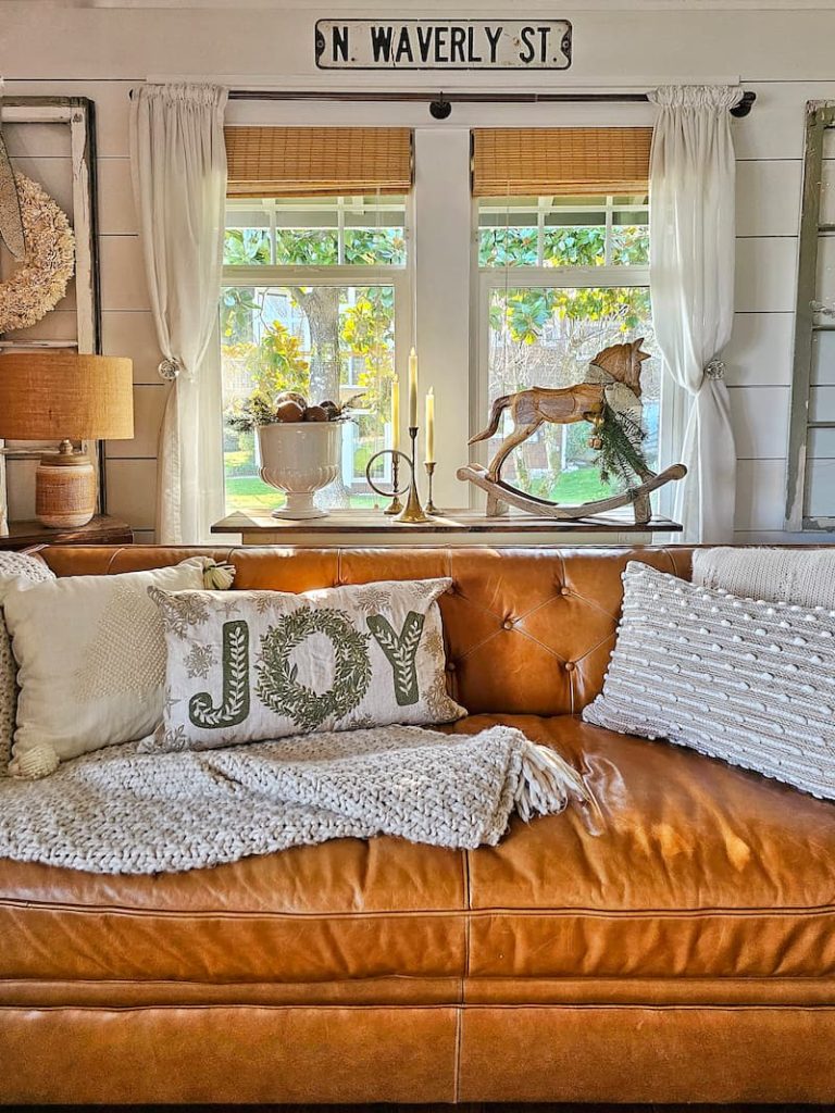Green and white Christmas decor: leather couch with Joy pillow