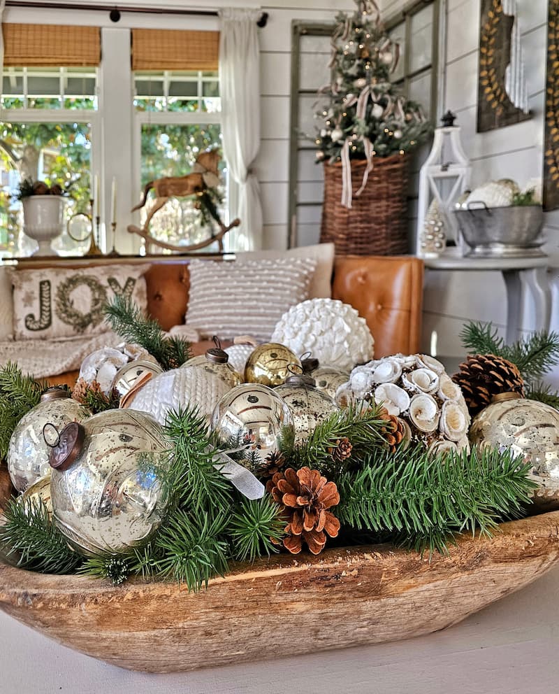 vintage classic Christmas decorations: wooden dough bowl filled with pine cones, greenery, and ornaments