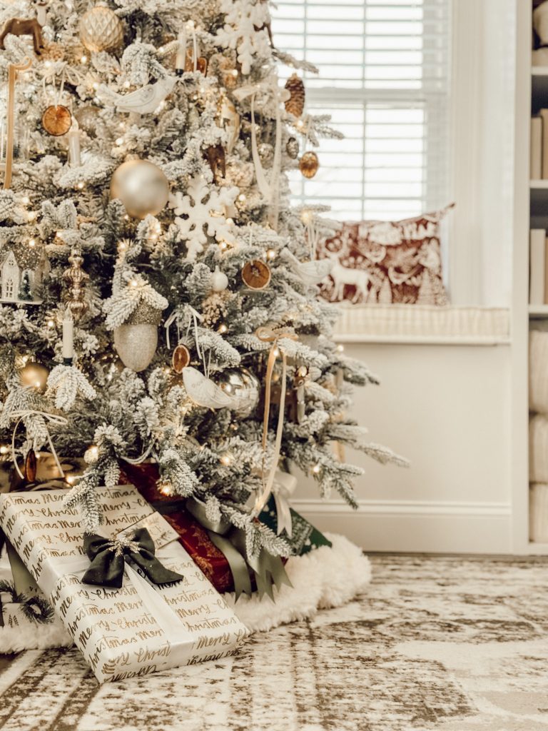 Christmas home decor ideas: flocked Christmas tree decorated with dried oranges and wrapped gifts underneath