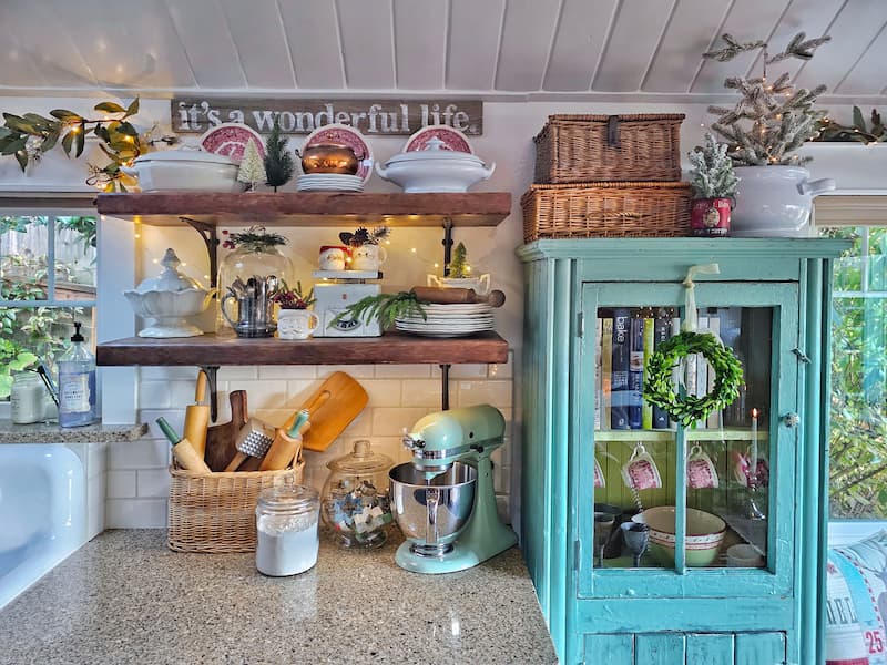 Mixing vintage and modern Christmas decor: open shelving with vintage collections and turquoise cabinet