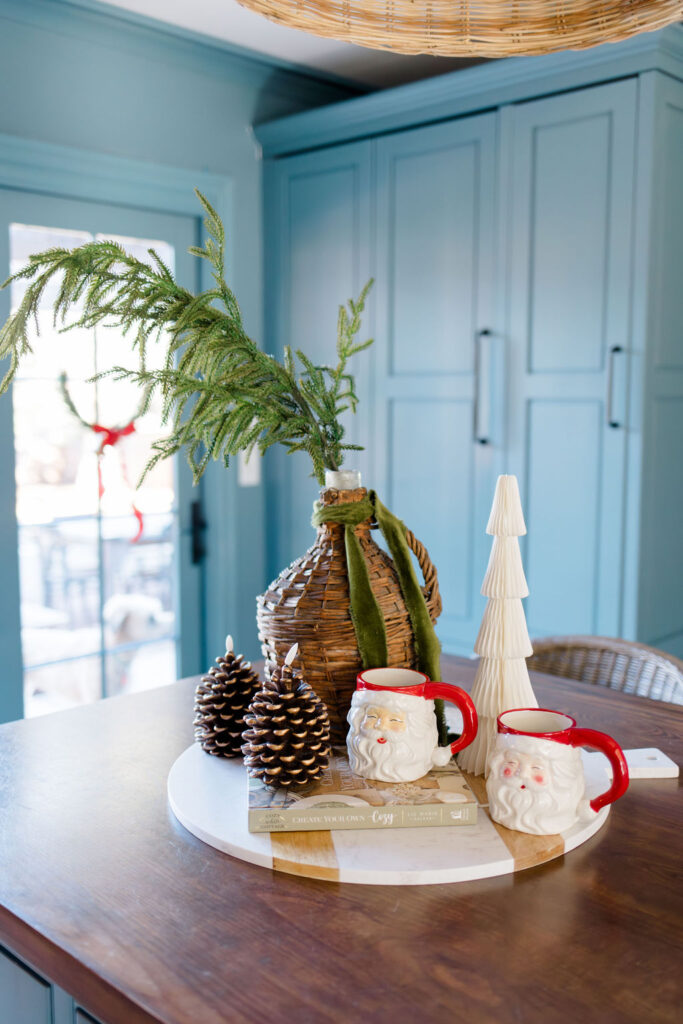 Christmas home decor ideas: Santa mugs, pinecone candles and greenery on kitchen island