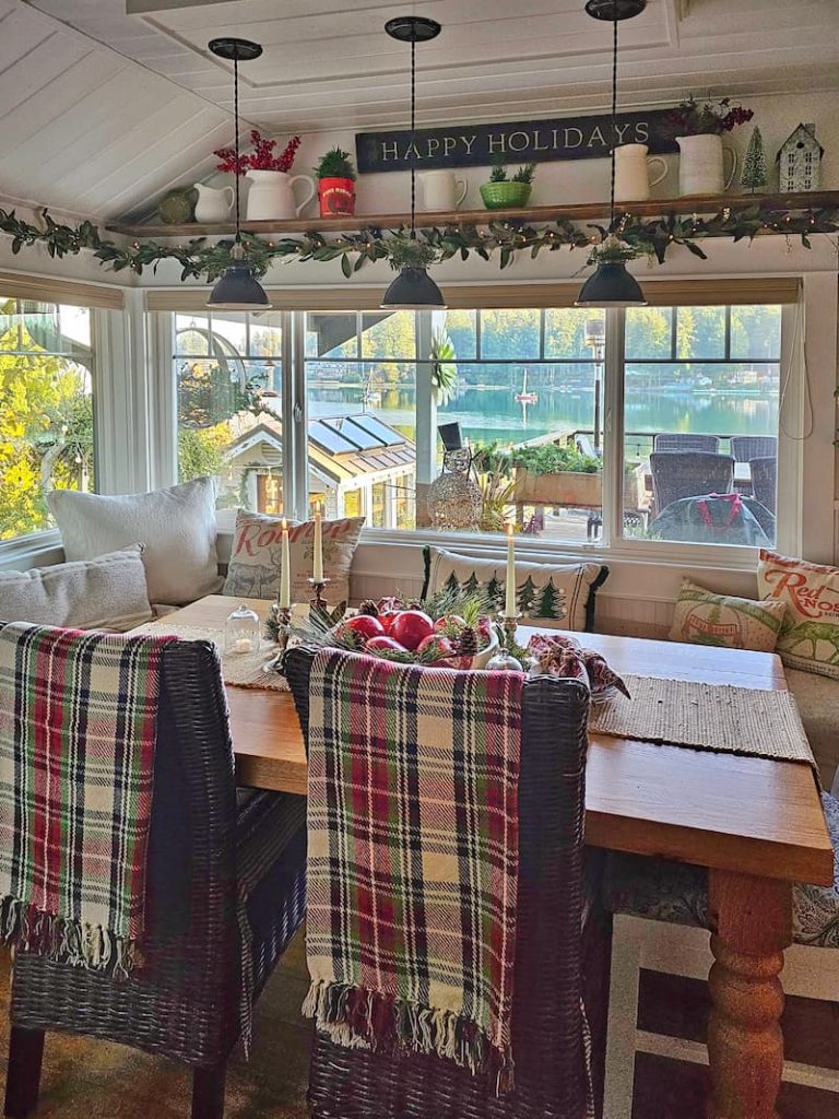 Christmas natural elements: dining table with plaid blankets and garland hanging over the windows
