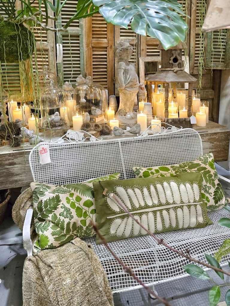 vintage bench and green pillows with lit candles in the background