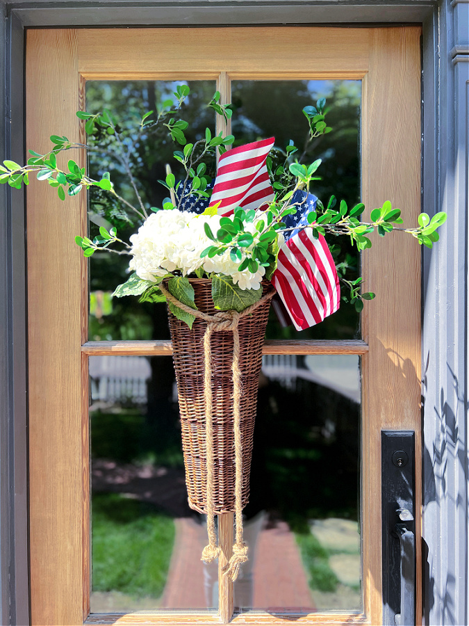hanging basket with 4th of July flowers and flags on the door The Tattered Pew