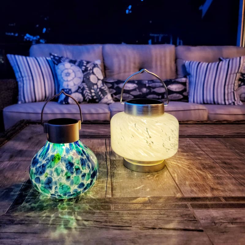 cream and blue and green solar lanterns on outdoor coffee table
