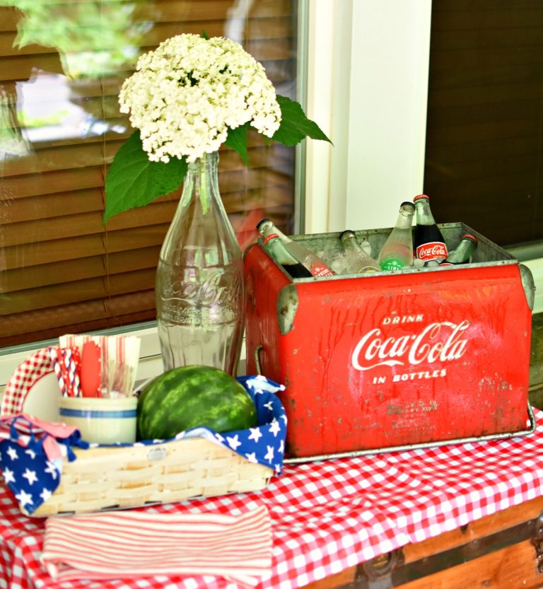 patriotic outdoor decorating ideas: vintage red Coca-Cola cooler and glass bottle with white hydrangea Follow the Yellow Brick Home