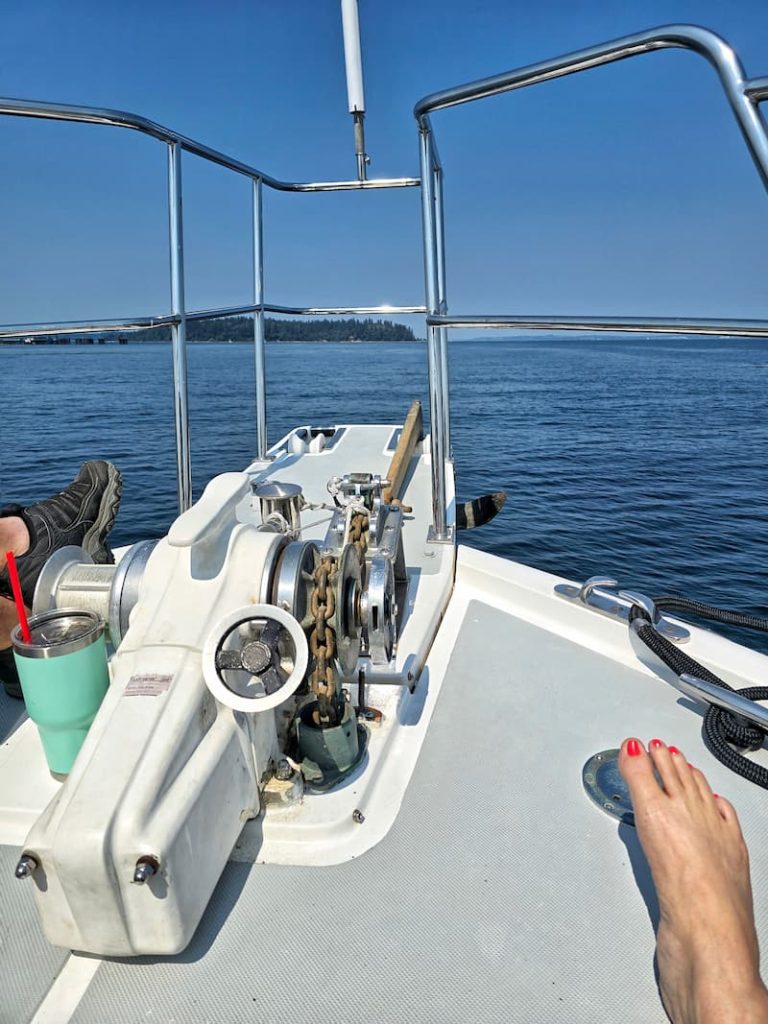 sitting at the front of the boat by the anchor