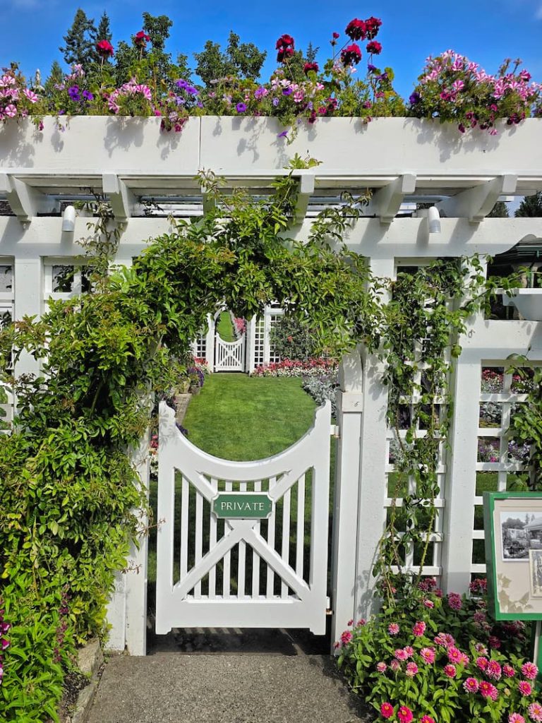 The white picket fence gate entrance to the private garden in Butchart Gardens