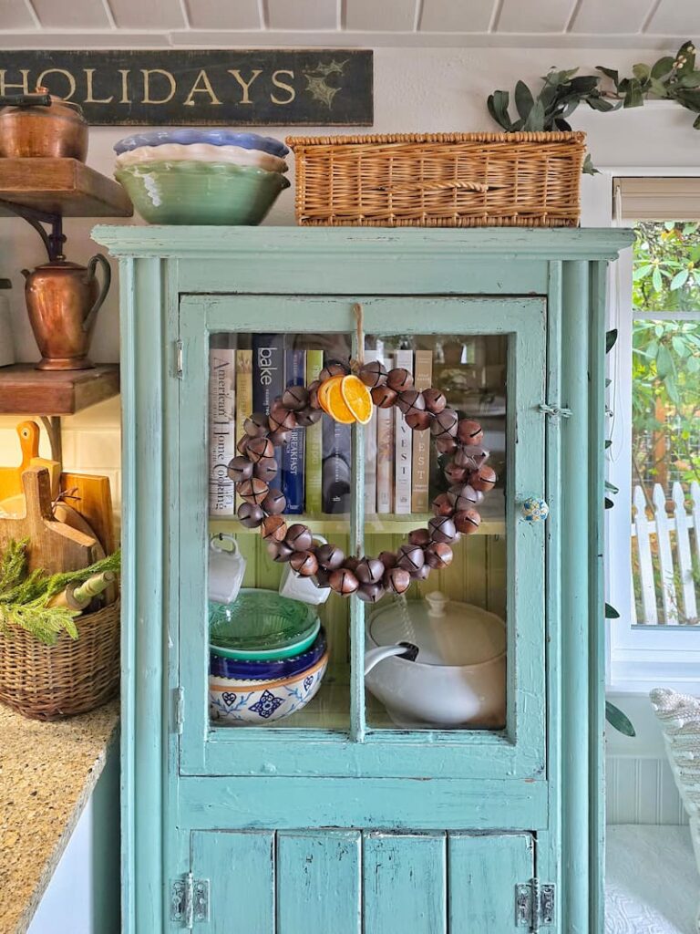 aqua cabinet with rustic bell wreath