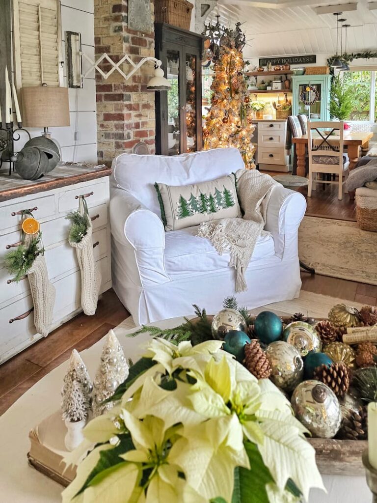 white slipcovered chair with Christmas tree pillow