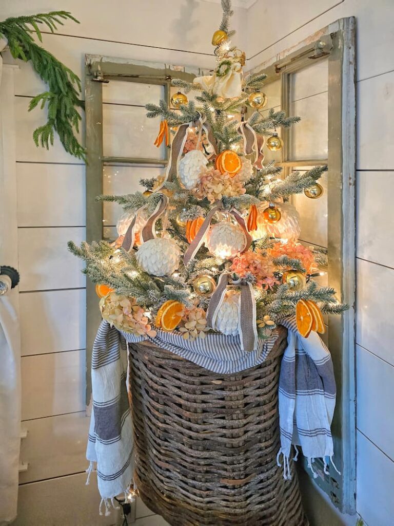 Small flocked Christmas tree with dried oranges as decorations