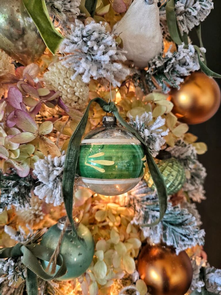 green and silver vintage ornament hanging on the Christmas tree