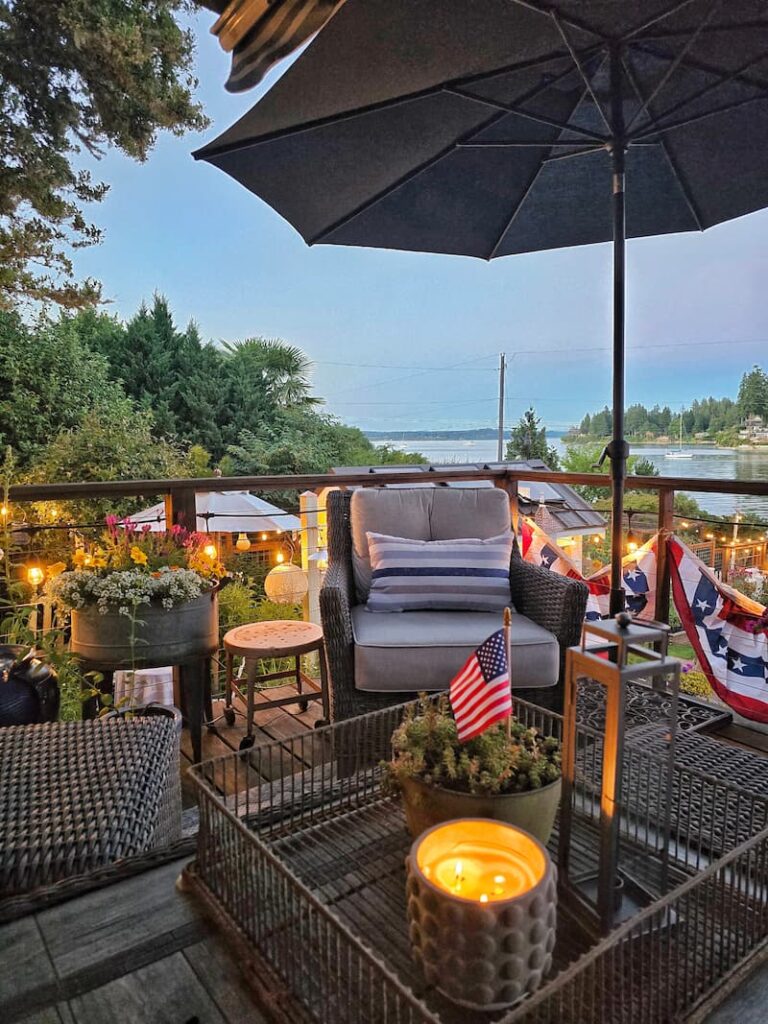 on the deck in the evening on the 4th of July with outdoor furniture, candles, and bistro lights