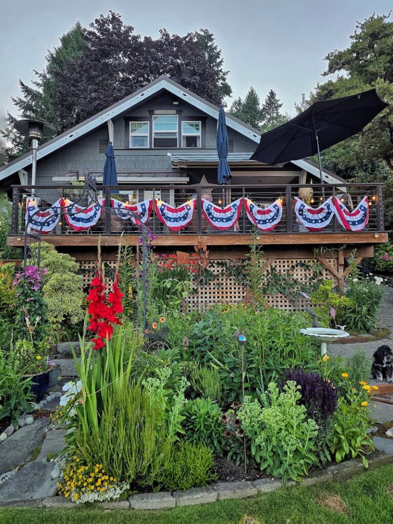 gray cottage with patriotic bunting hanging from the deck