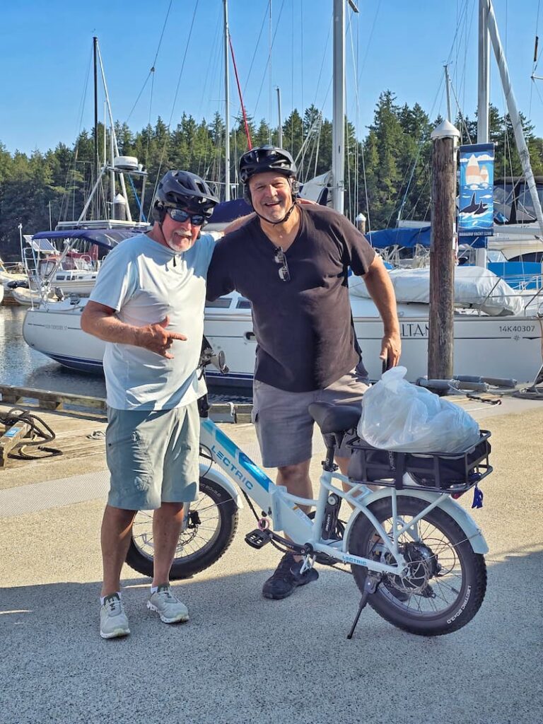 2 men posing in front of their bikes