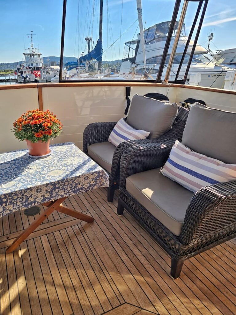 Cockpit of our Kadey Krogen Whaleback with a table, chairs, and a potted fall mum