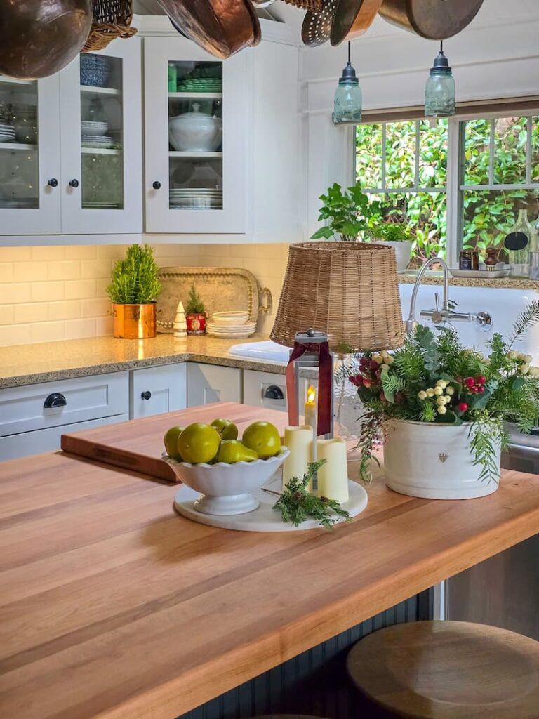 kitchen island with greenery arrangement and pears in a bowl