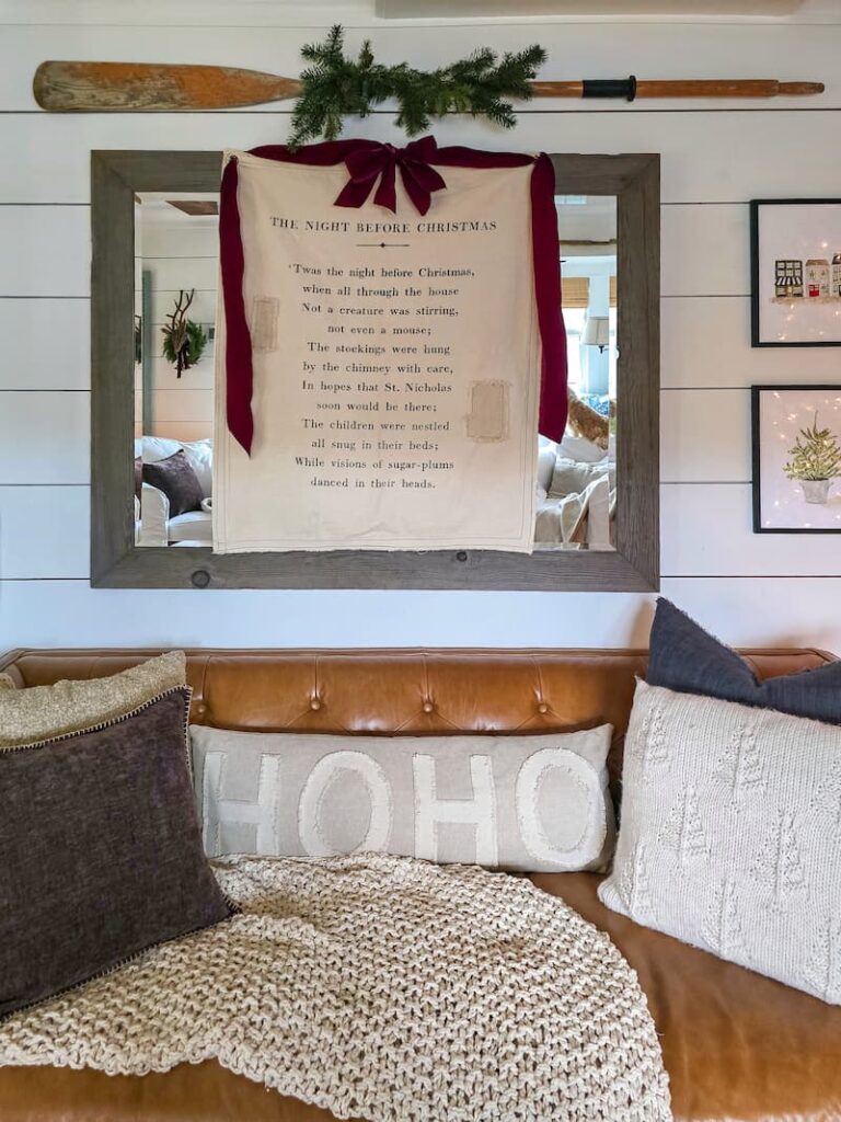 Ho Ho pillow on leather couch with Christmas decorations around the living room