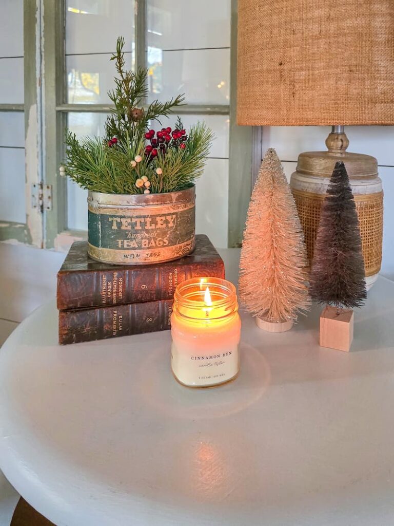vintage tin with greenery, books, a candle, and bottlebrush trees