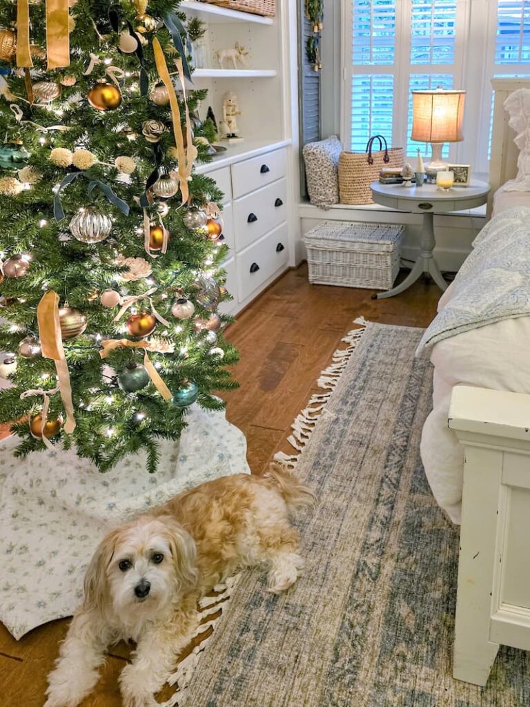 neutral colored Christmas tree in cottage bedroom with cream dog laying under ti