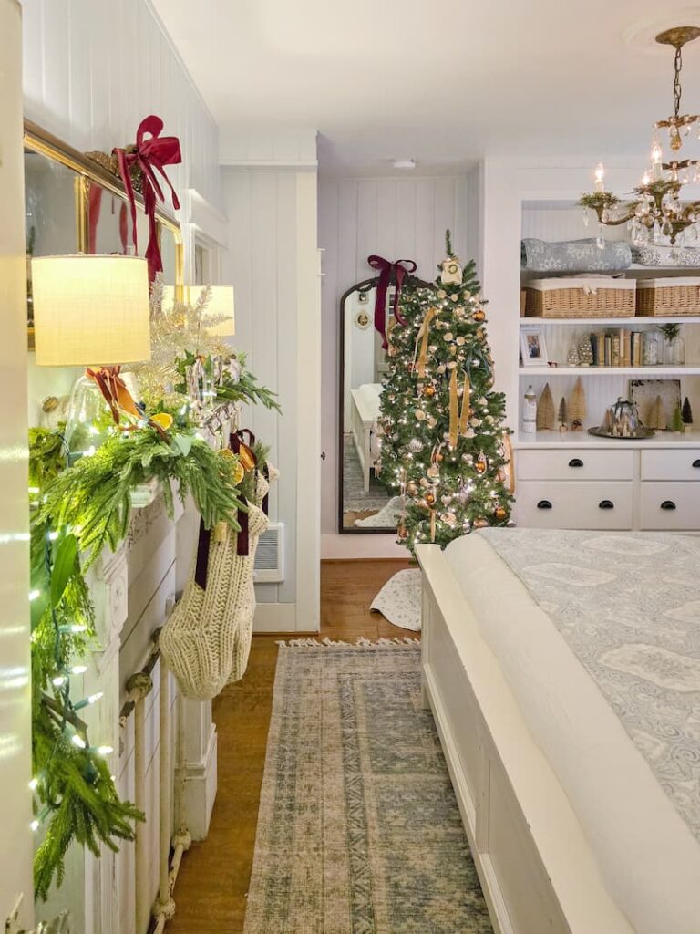 Cottage bedroom decorated for Christmas with Christmas tree and faux fireplace mantel