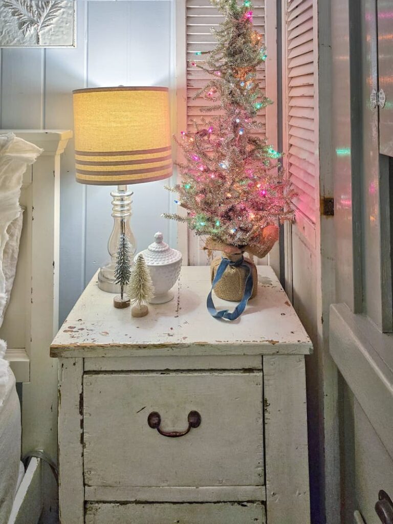 vintage tinsel mini Christmas tree on cream nightstand for Christmas