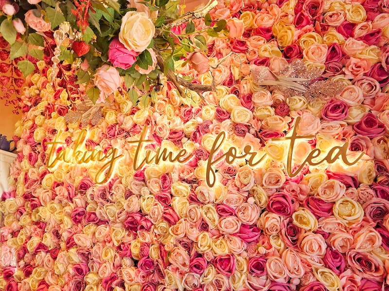 taking time for tea sign with roses on the wall