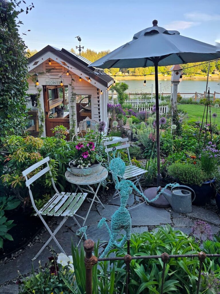 greenhouse and a bistro table and chair with umbrella at dusk