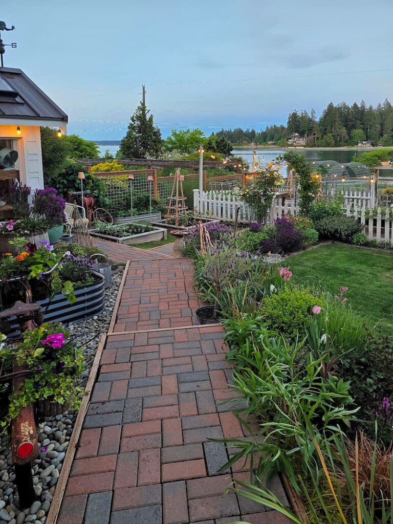 paver pathway through the garden at dusk