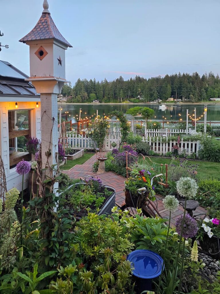 cottage garden view in May with birdhouse, and view of the bay