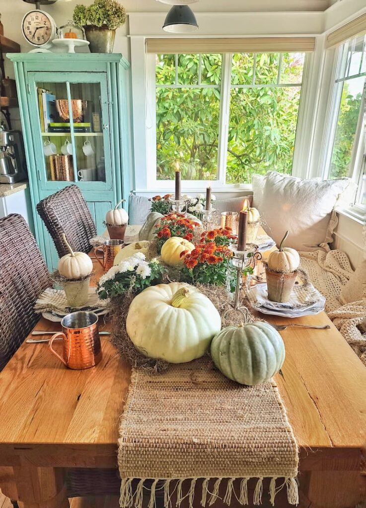 fall table using pumpkins, mums, copper, and candles