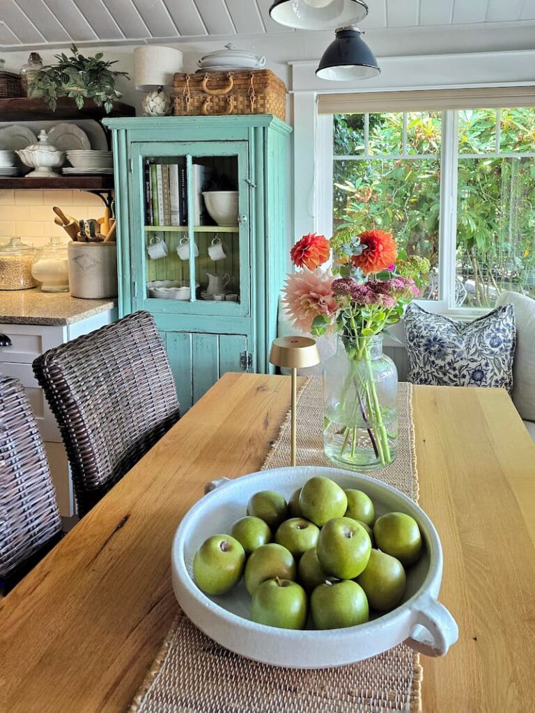Cottage kitchen dining area with garden flowers on the table in late summer