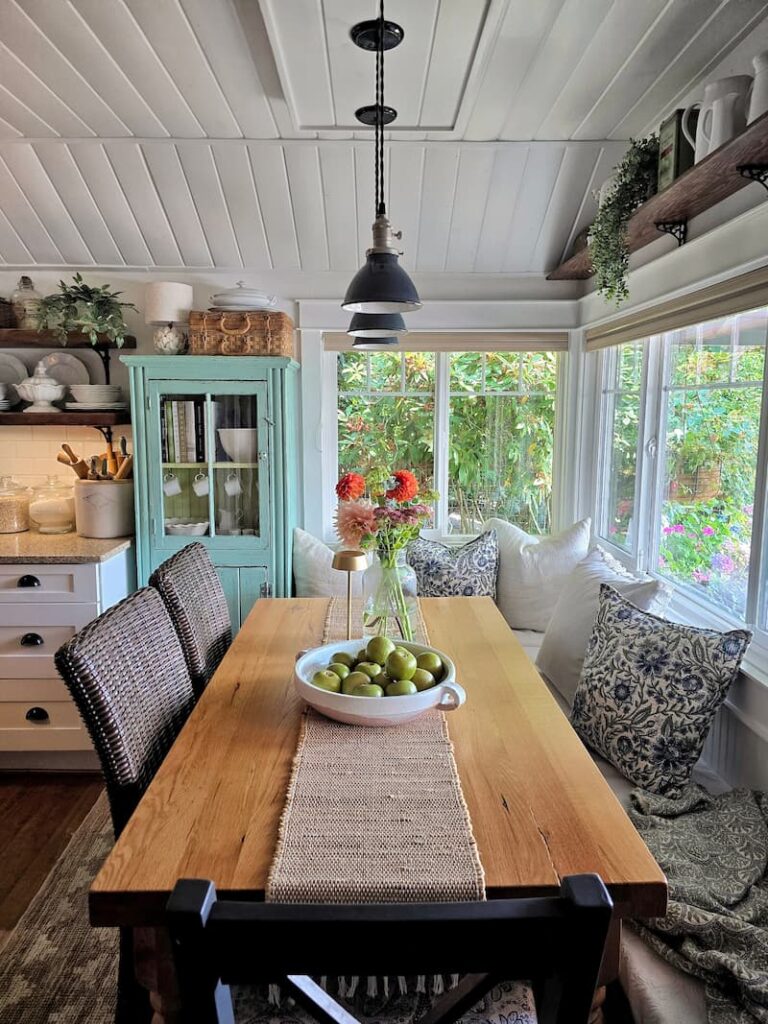 Bright cottage kitchen eating area with summer flowers and natural light