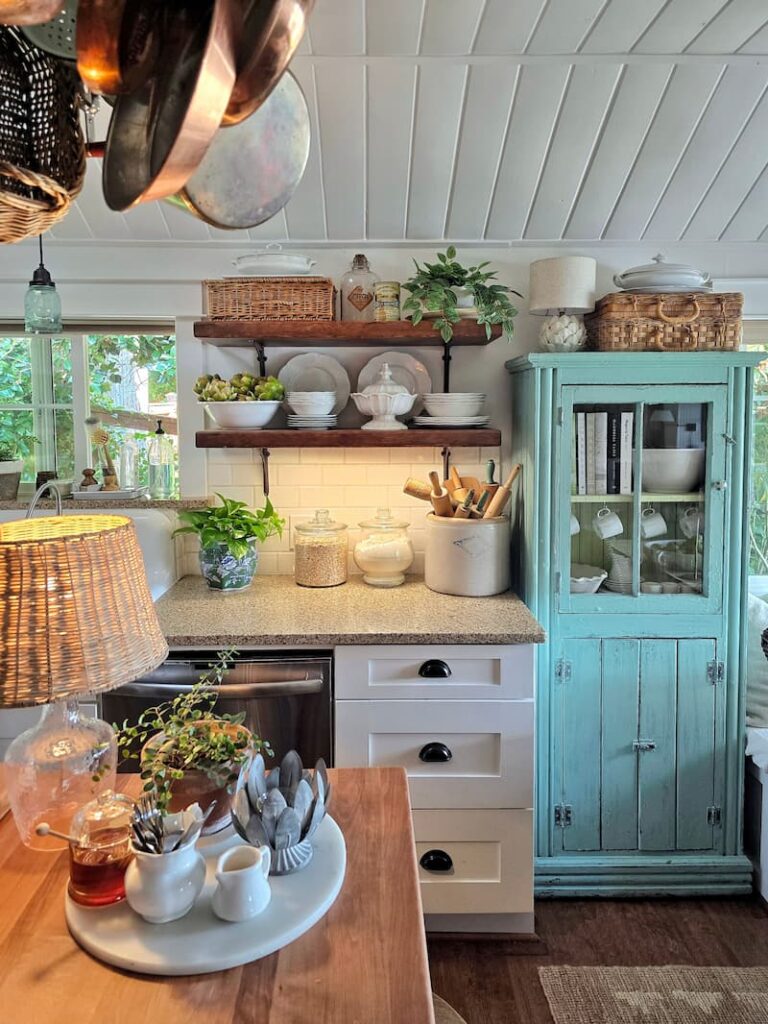 Cottage kitchen with turquoise hutch and open shelving in late summer