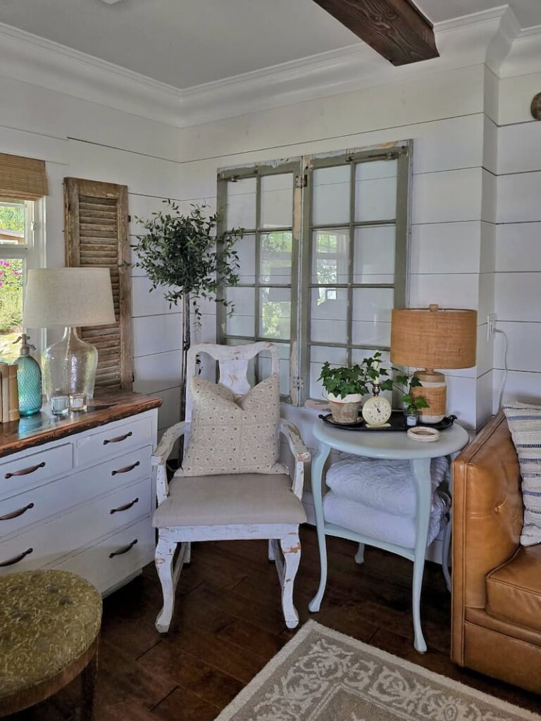 living room with green vintage window hung on shiplap walls
