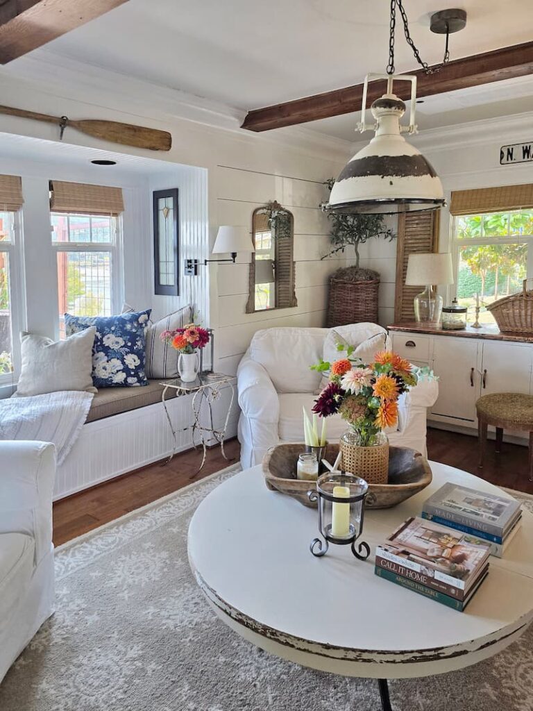 Late summer living room in a 1920 beach cottage on Puget Sound with fresh garden flowers