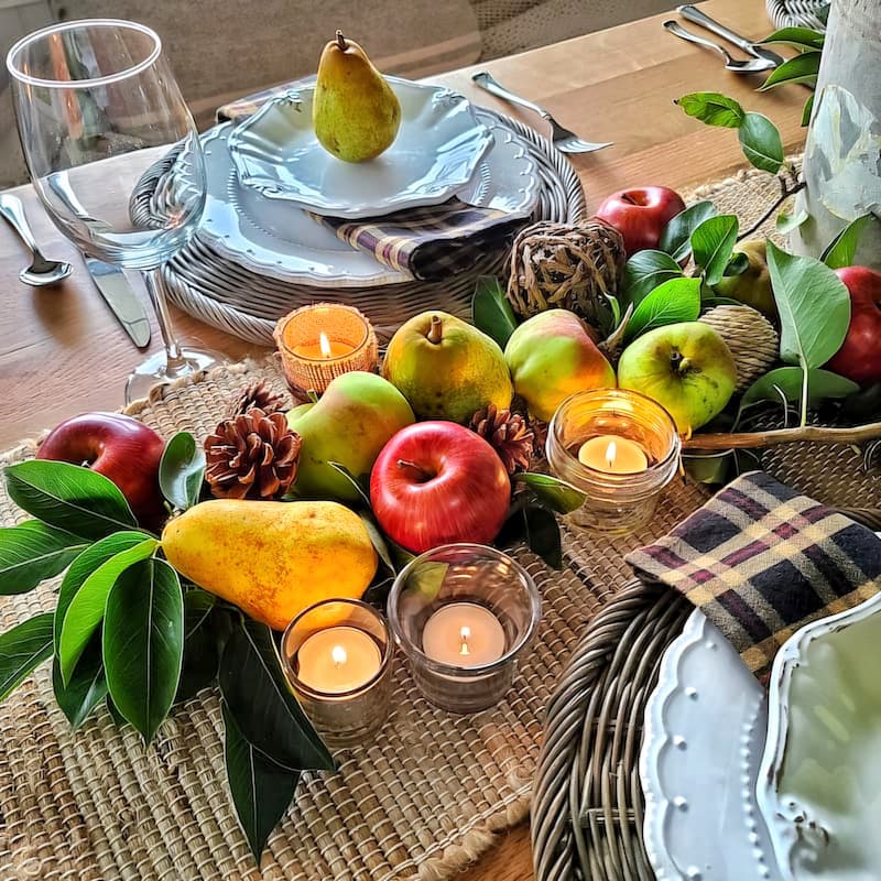 red apples and green pears with candle light as a centerpiece for fall table
