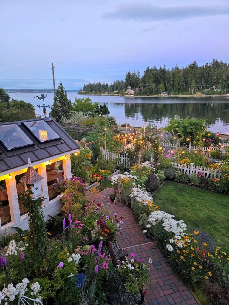 Evening light over a Pacific Northwest cottage garden and Puget Sound bay in summer