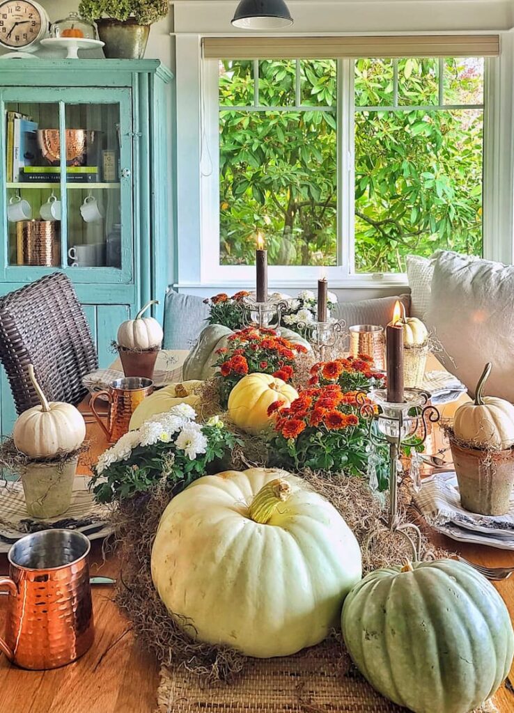 fall table with pumpkins, mums, and candlelight