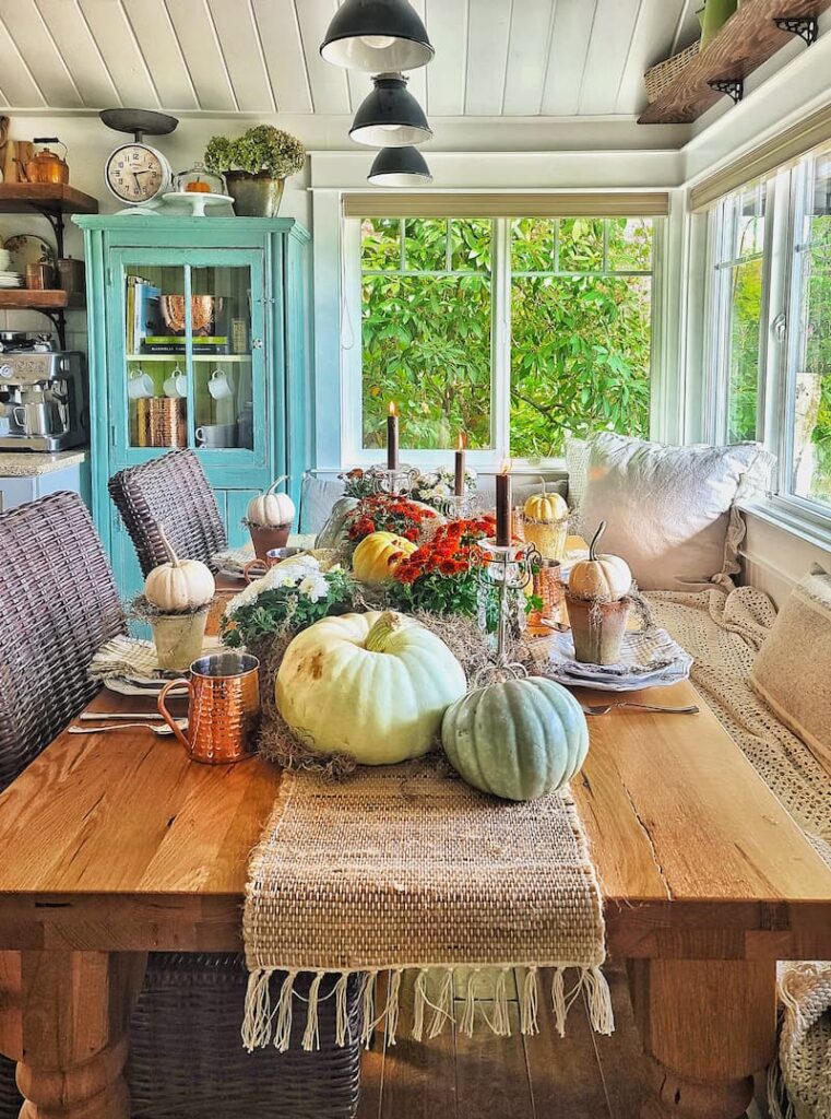 fall table in a cottage kitchen with pumpkins and mums as the centerpiece