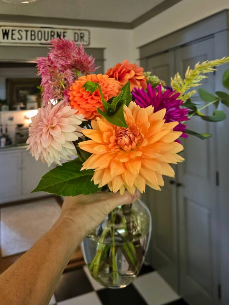 holding a vase of Fresh cut flowers from the garden 