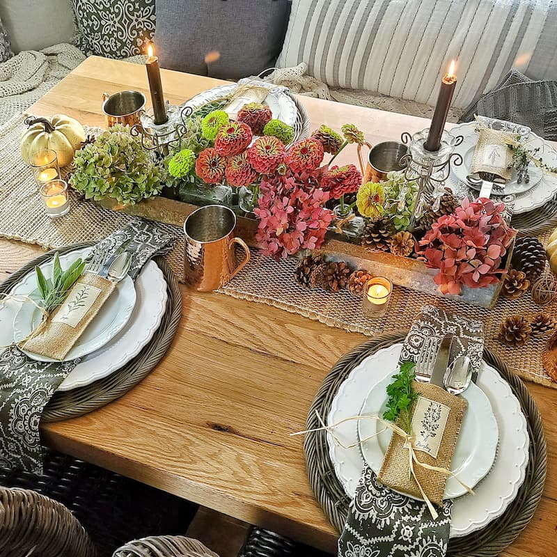 rose and green colored hydrangeas and zinnias and herbs on fall table
