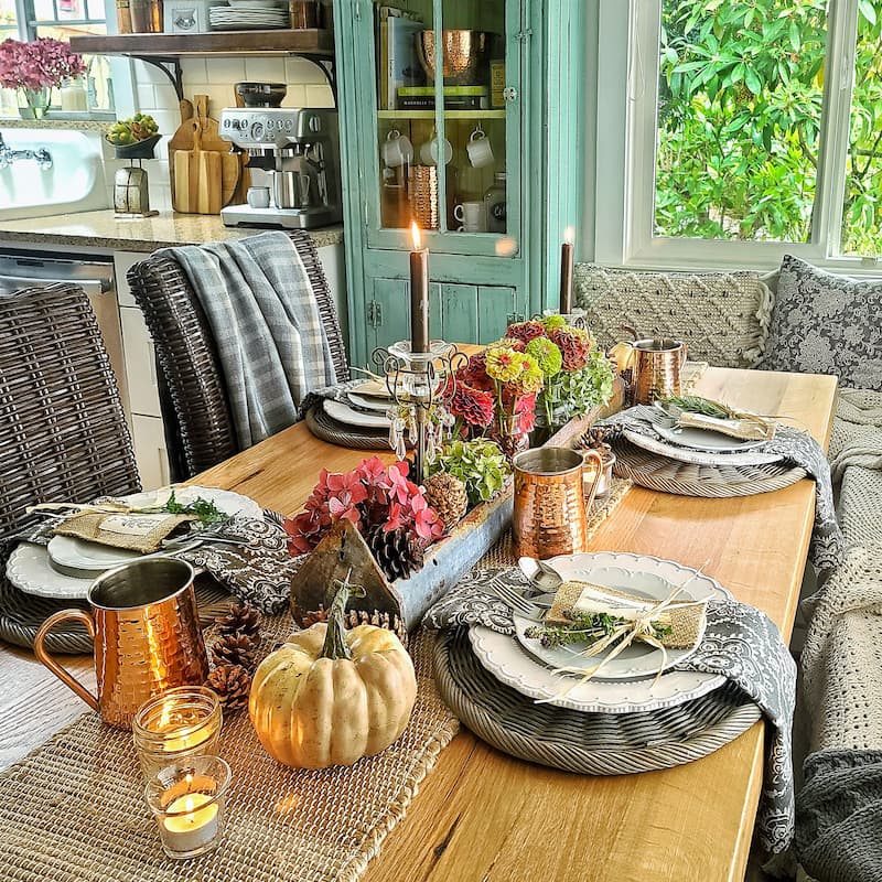 kitchen table with flowers, herbs, and copper