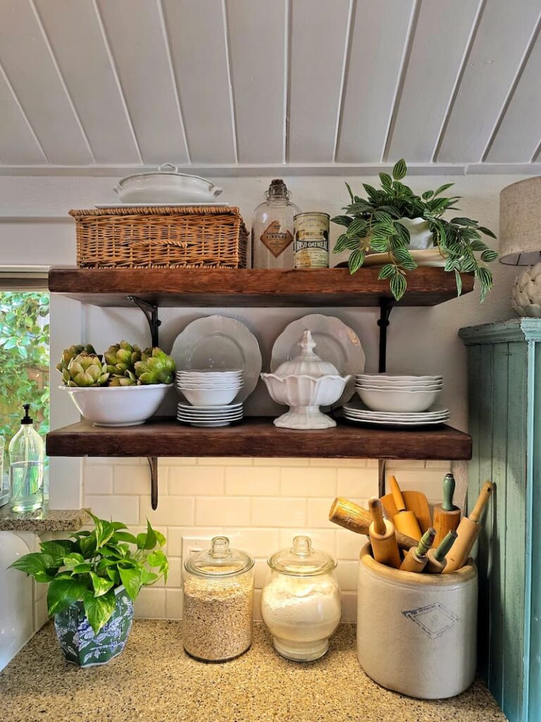 Open kitchen shelving displaying a vintage ironstone collection in a Pacific Northwest cottage