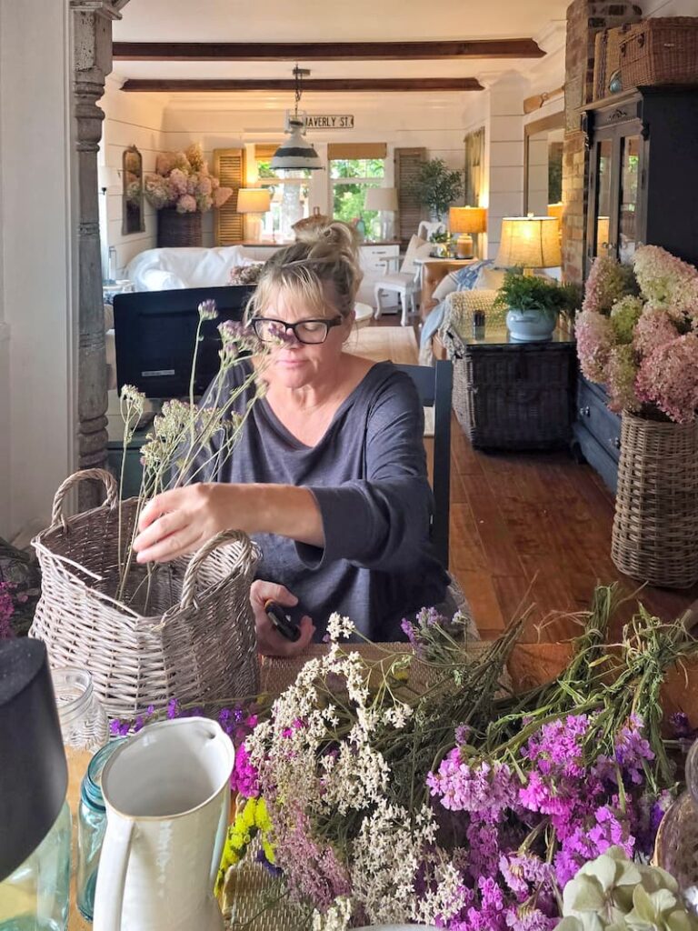 dried flowers from the cut flower garden being arranged in a basket for fall decor