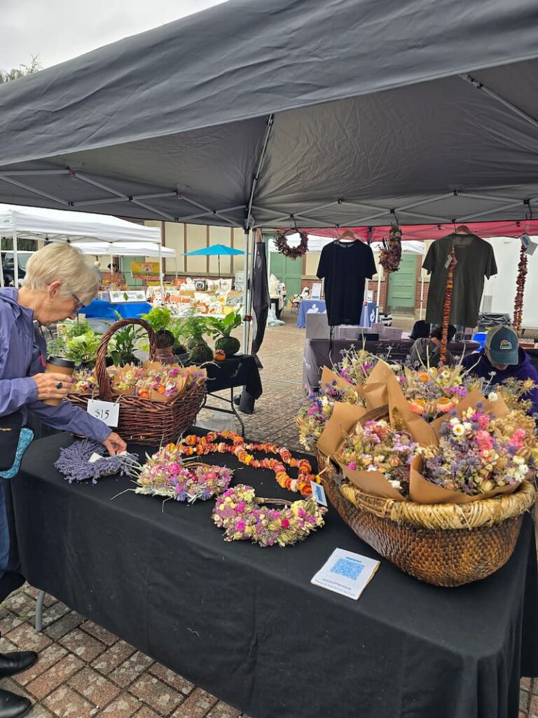 Dried flower bundles and wreaths at a booth at the Anacortes Farmers Market